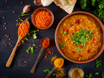 Indian dal. Food. Traditional Indian soup lentils. Indian Dhal spicy curry in bowl, spices, herbs, rustic black wooden background. Top view. Authentic Indian dish. Overhead. Flat lay Simple Happy